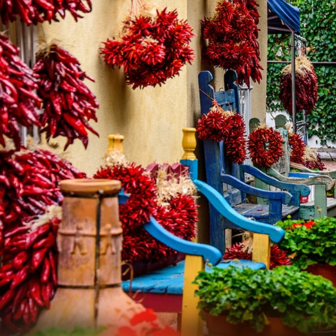 Ristras of all shapes and sizes hanging next to blue benches
